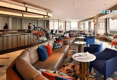 Bright breakout lounge with curved leather sofas and blue armchairs.