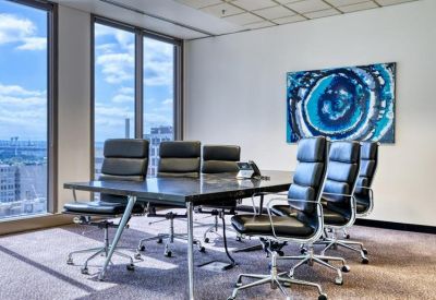Professional meeting room with a large black table, leather chairs, and city skyline views.