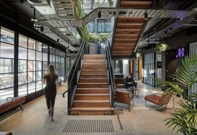 Modern lobby area featuring a wooden staircase and industrial-style windows.