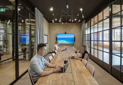 Conference room with a long wooden table and modern chandelier.