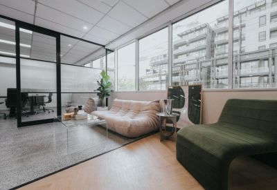 Spacious communal lounge featuring a low-profile tan sofa and floor-to-ceiling windows.