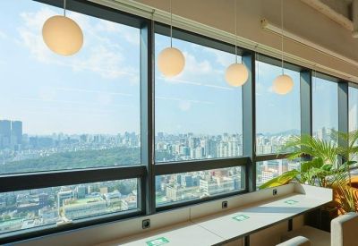 Window-side hot desks with city views and spherical pendant lights.