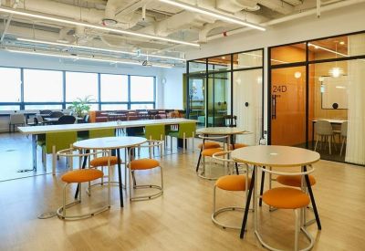 Bright coworking space with round tables and orange stools.