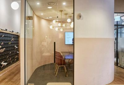 Curved white feature wall leading into a glass-walled private office suite.