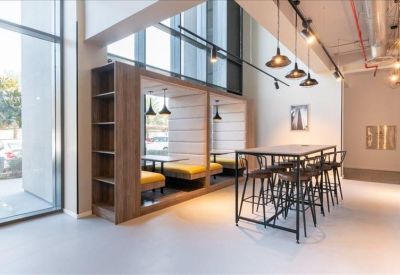 Communal break area with built-in booth seating, high tables, and stylish hanging lights.