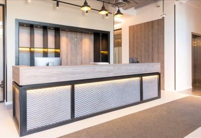 Sleek wood and stone reception desk with integrated lighting and pendant lamps.