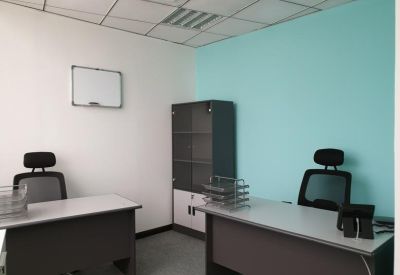Dual-desk workspace with a turquoise feature wall and storage cabinet.
