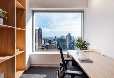 Private office suite with a wood desk, shelving, and expansive city skyline views.