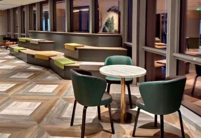 Modern breakout area featuring a marble-topped cafe table and tiered wooden bench seating.