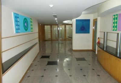 Bright office corridor with polished floors and colorful abstract wall art.