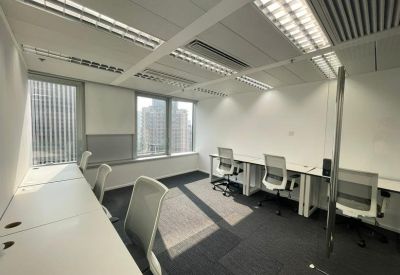 Internal office suite with white desks, grey carpet, and large windows providing natural light.