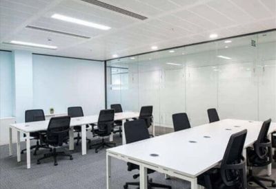 Two long tables with six chairs in a glass-walled meeting room.