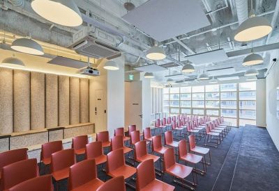 Lecture-style seminar room with rows of orange chairs and modern overhead lighting.