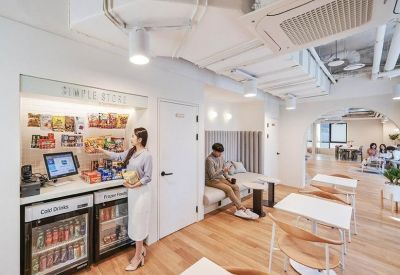 Self-service refreshment station with snacks and drinks next to a minimalist seating area.