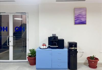 Refreshment station with a blue cabinet, coffee machine, and water dispenser.