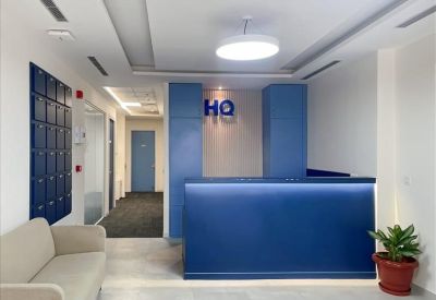 Bright reception area featuring a sleek blue front desk and white sofa.