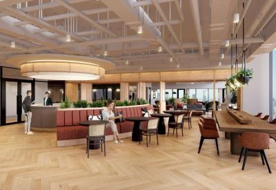 Cafe-style seating area with red banquettes, round tables, and an industrial-chic ceiling.