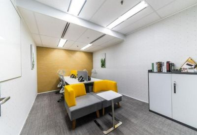 Small breakout room with yellow armchairs and a tan feature wall.