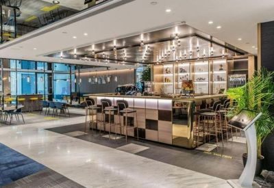 Spacious communal cafe area with a large modern bar and warm overhead lighting.