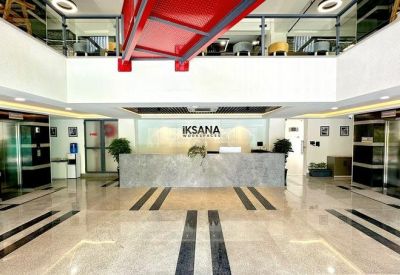 Spacious reception lobby with a marble-textured front desk and polished tile flooring.