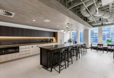 Spacious communal kitchen and dining area with dark wood cabinetry and a large island bench.