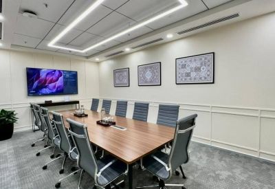 Sleek professional meeting room with a wooden table, ergonomic chairs, and wall-mounted art.