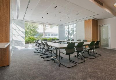 Modern conference room with a U-shaped table and views of greenery.