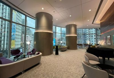Spacious lounge area with large pillars, a grand piano, and panoramic windows.