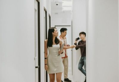 Bright white corridor with people walking and talking between office doors.