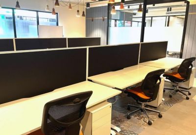 Open-plan workspace with rows of desks, ergonomic chairs, and pendant lighting.