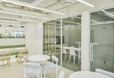 Bright glass-walled meeting rooms adjacent to a white communal dining area.