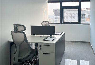 Bright workspace featuring two workstations with views of the surrounding city architecture.