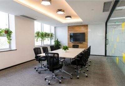 Contemporary meeting room with a large table, ergonomic chairs, and wall-mounted TV.