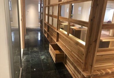 Polished corridor with floor-to-ceiling wooden lattice partitions and reflective dark flooring.