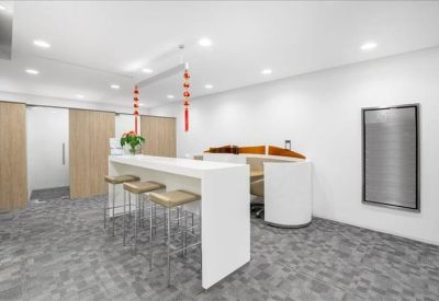Communal break area featuring a high white breakfast bar with wooden stools and red lanterns.