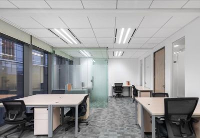Spacious open-plan office with glass partitions and rows of white desks.