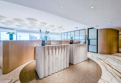 Elegant reception area with fluted marble desks and warm wood paneling.