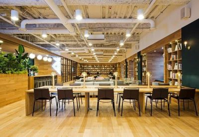 Long communal workspace with individual desk lamps and rows of black chairs.