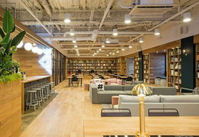 Expansive library-style lounge with long wooden tables and rows of bookshelves.