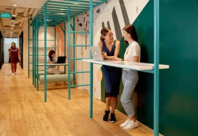 Modern corridor featuring creative teal-colored scaffolding workstations and standing desks.