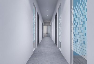 Long bright corridor with decorative glass privacy screens and concrete-style flooring.