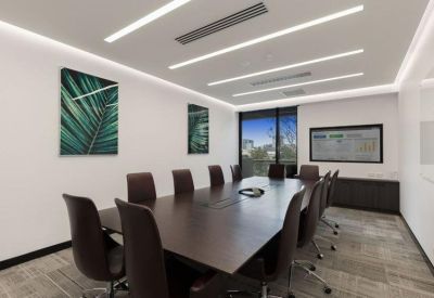 Large professional boardroom with a dark wood table and botanical wall art.