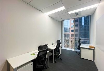 Private two-person office suite with white desks and city views through a large window.
