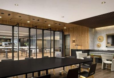 Large communal table and seating area with glass partitions and wood paneling.