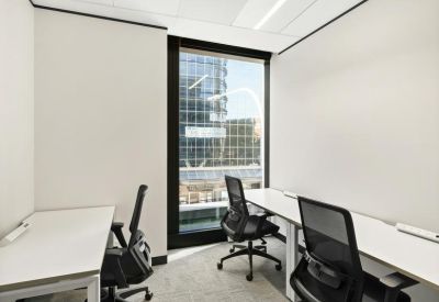 Two-person private office suite with white desks and black ergonomic chairs.
