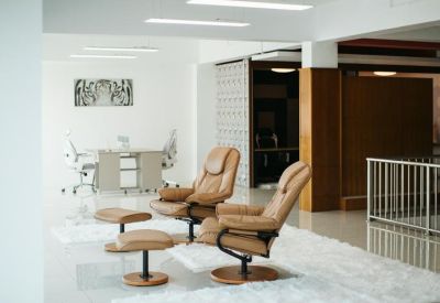 Lounge area with tan leather recliners and a plush white rug.