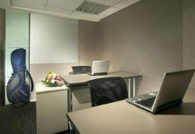 Private office suite with two desks, laptops, and a blue golf bag.