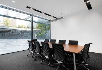 Bright conference room with floor-to-ceiling windows and black chairs.