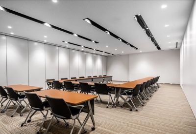 Large U-shaped training room with white partitions and multiple tables.