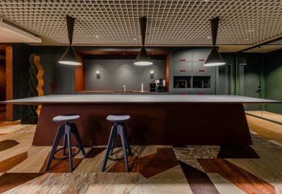 Modern communal kitchen area with a dark wood island and pendant lighting.